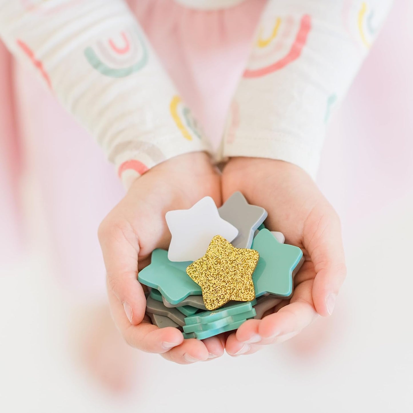 Colorful star jar reward system for kids, children's hands holding stars, star jar stars, replacement stars, blue star, gold star, pink star
