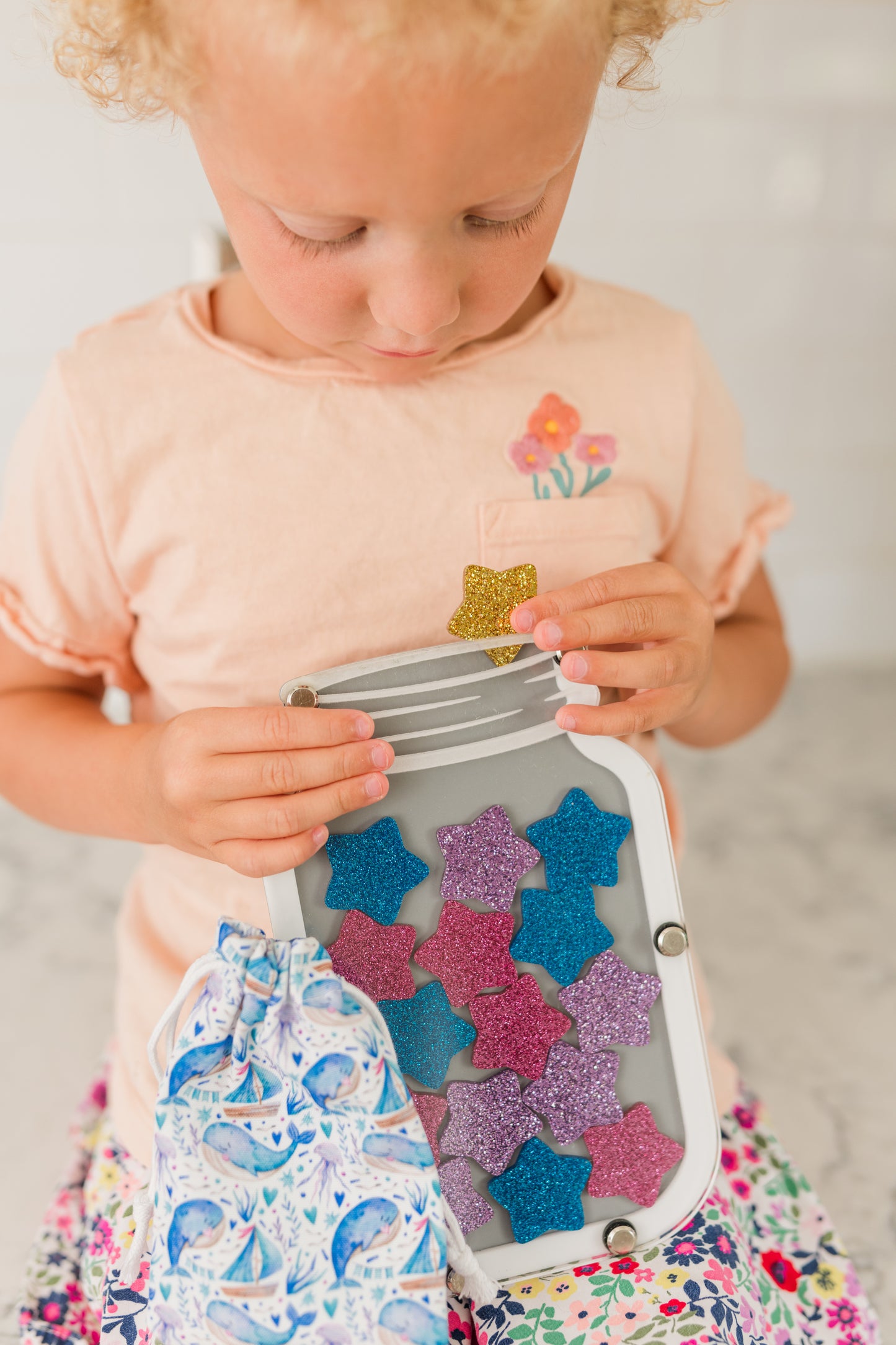 Colorful star jar reward system for kids, children's hands holding stars, star jar stars, replacement stars, blue star, gold star, pink star