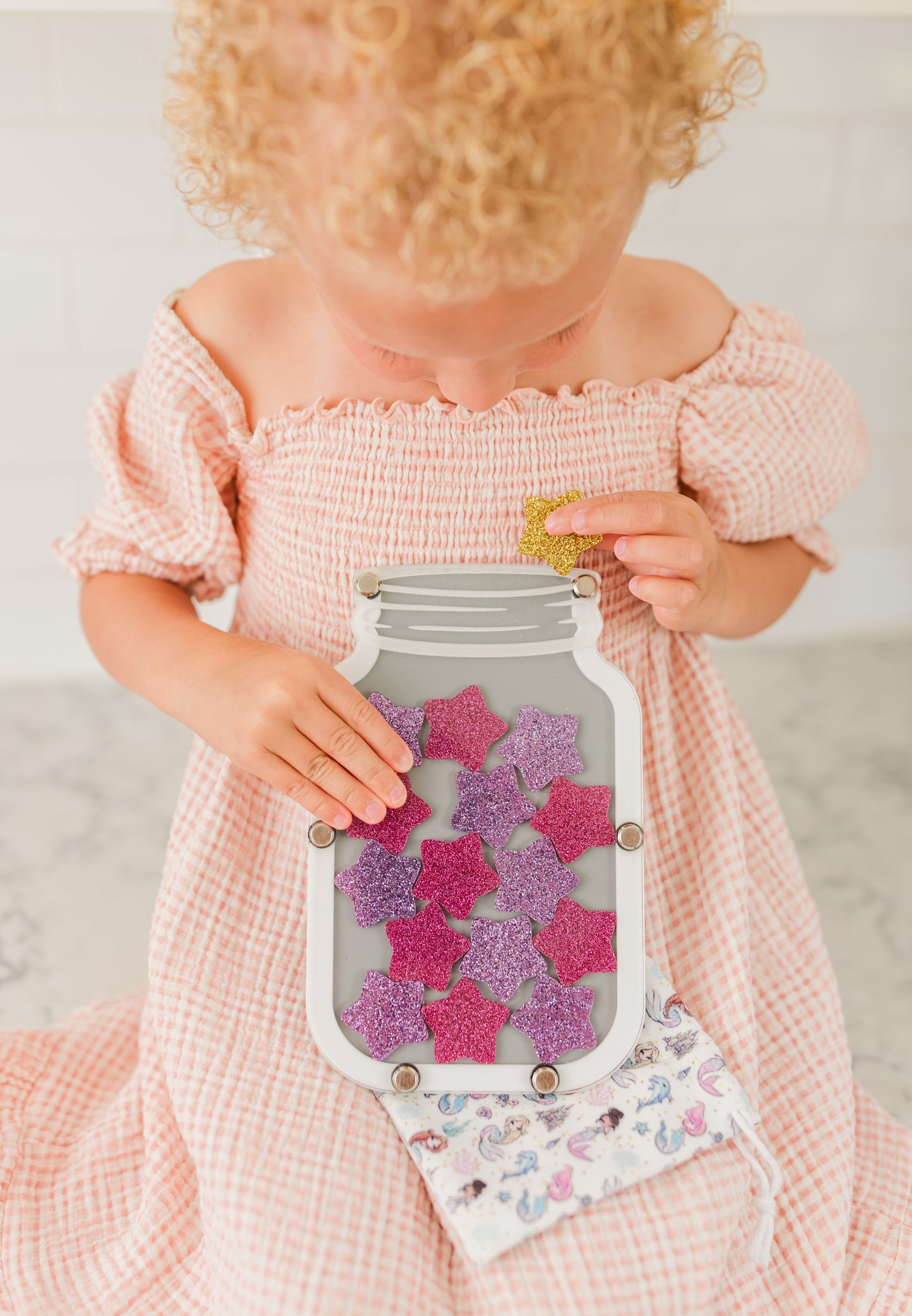 Colorful star jar reward system for kids, children's hands holding stars, star jar stars, replacement stars, blue star, gold star, pink star