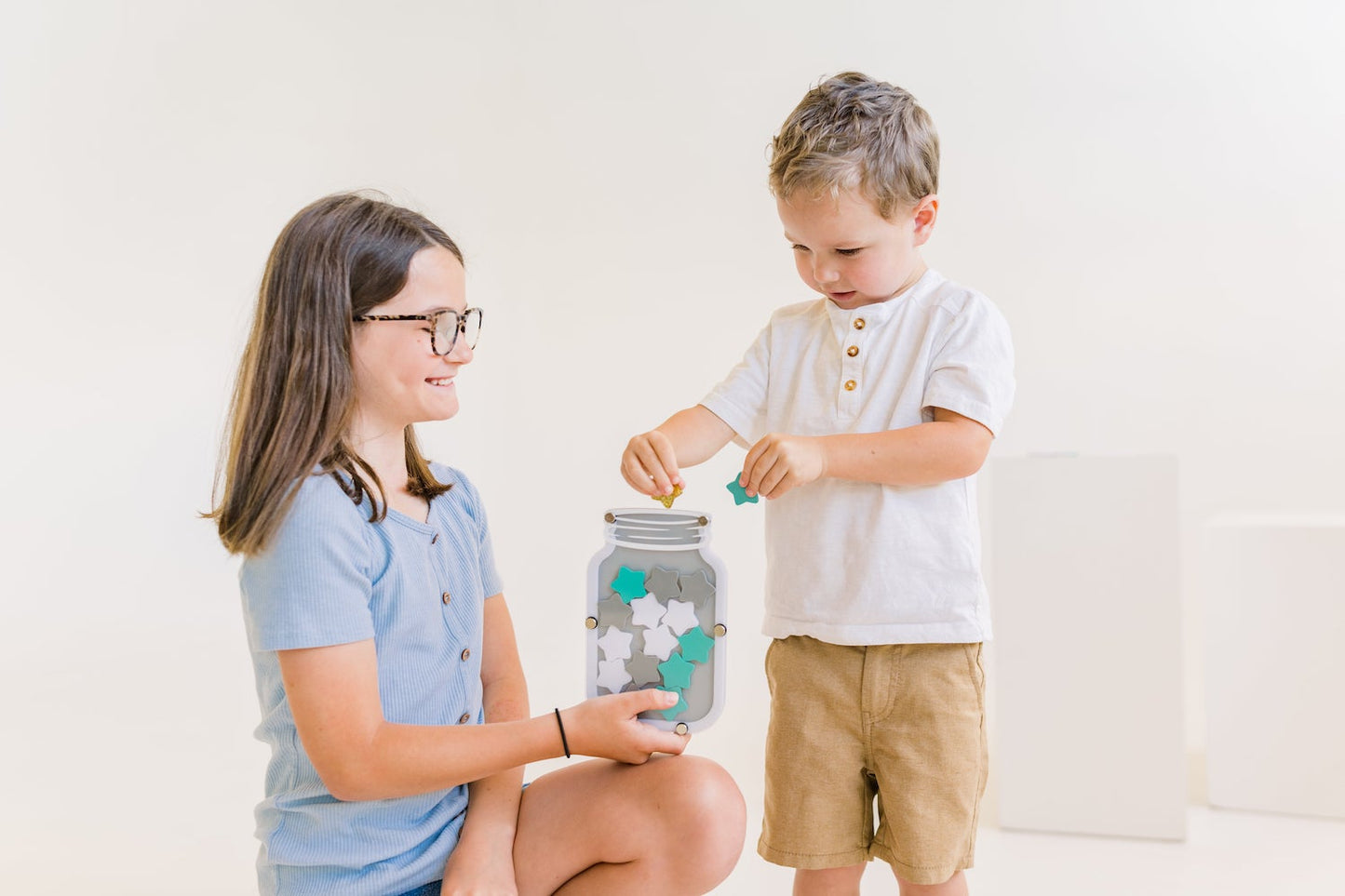 Colorful star jar reward system for kids, children's hands holding stars, star jar stars, replacement stars, blue star, gold star, pink star, girls holding star jar, potty training rewards, chore rewards